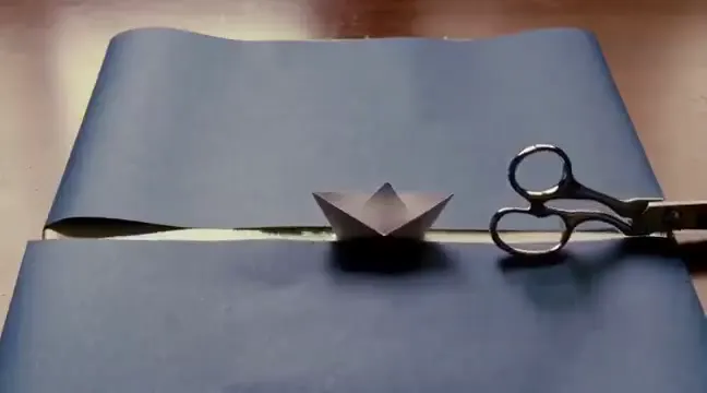 Frame from Scissors cut a path for a paper boat